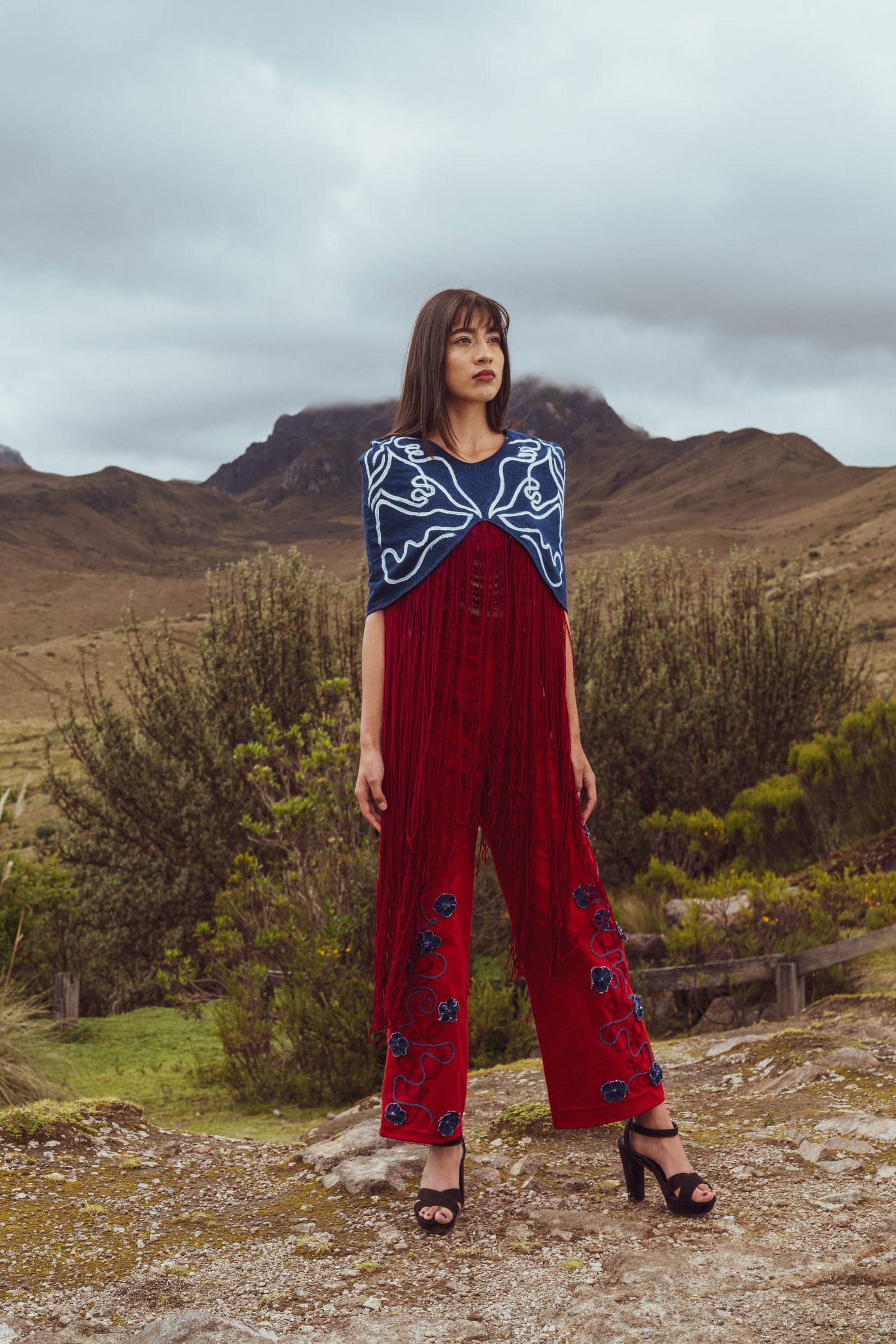 Modelo con atuendo rojo y azul frente a las montañas